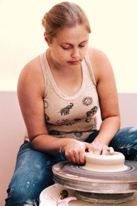 Jessica creates a vessel on a potter’s wheel using a process called throwing.